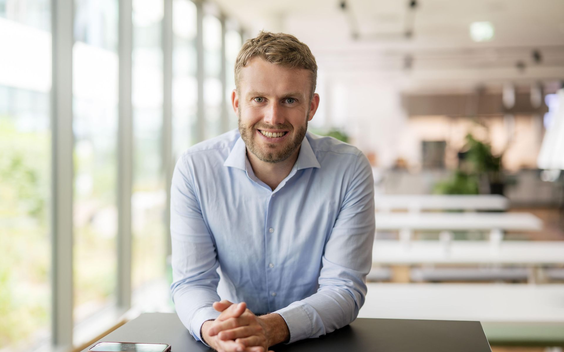 Mann mit Hemd lächelt in Kamera