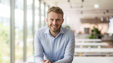 Mann mit Hemd lächelt in Kamera