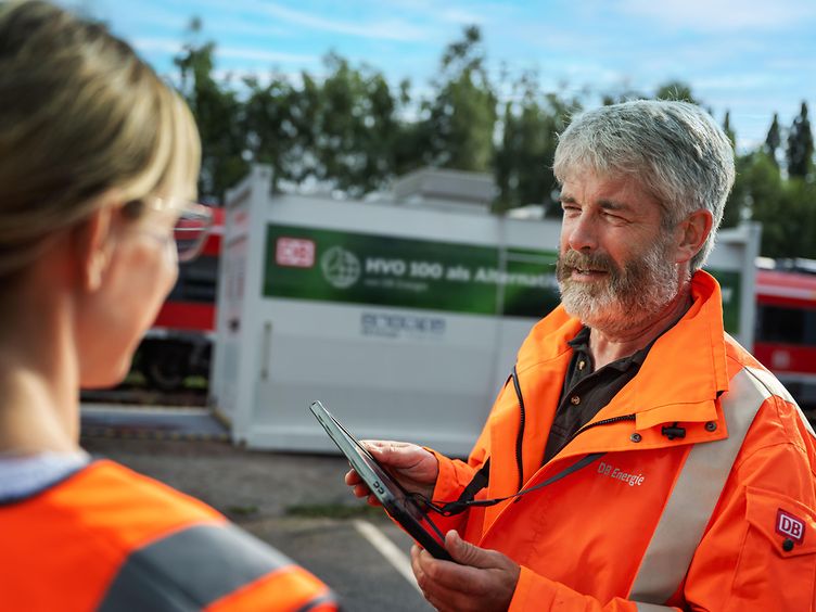 Mitarbeitende von DB Energie bei der digitalen Betreuung einer Tankanlage im Bahnumfeld mit Tablet und HVO-100-Infrastruktur.
