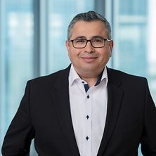 Mann mit Anzug und Hemd lächelt in die Kamera