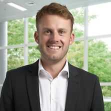 Mann mit Anzug und Hemd lächelt in die Kamera