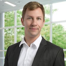 Mann mit Anzug und Hemd lächelt in die Kamera